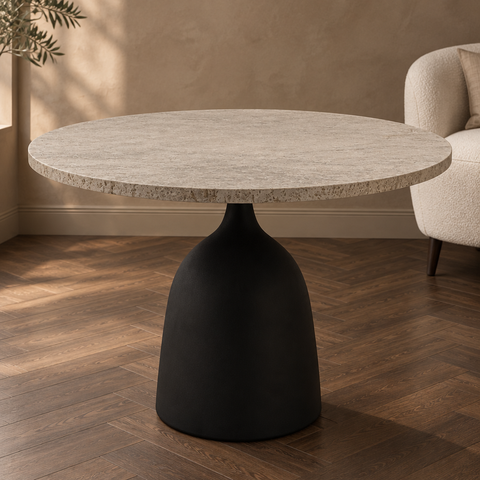 Ronde tafel met licht blad en zwarte voet in een warme interieursetting